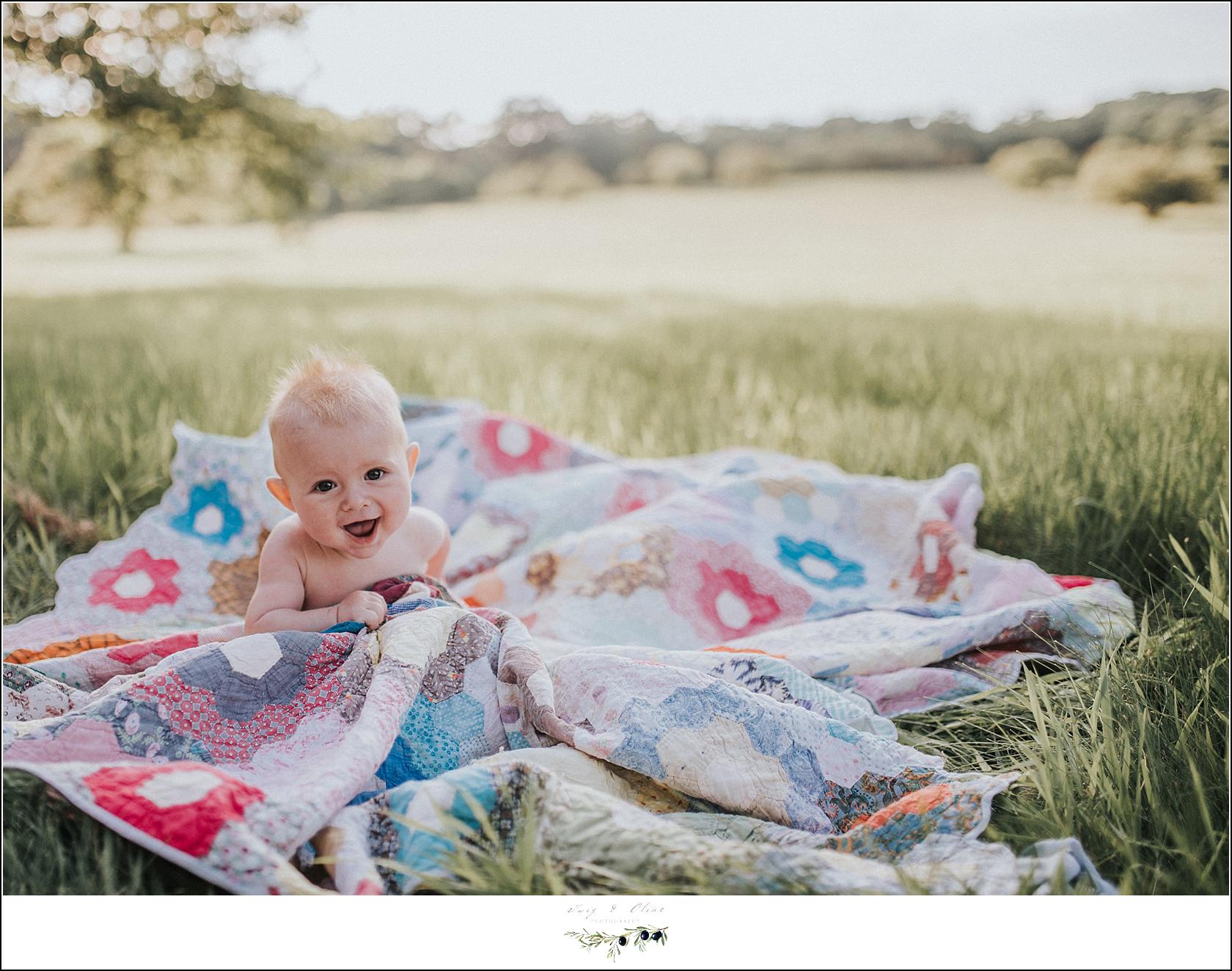 Baby on a blanket in a field
